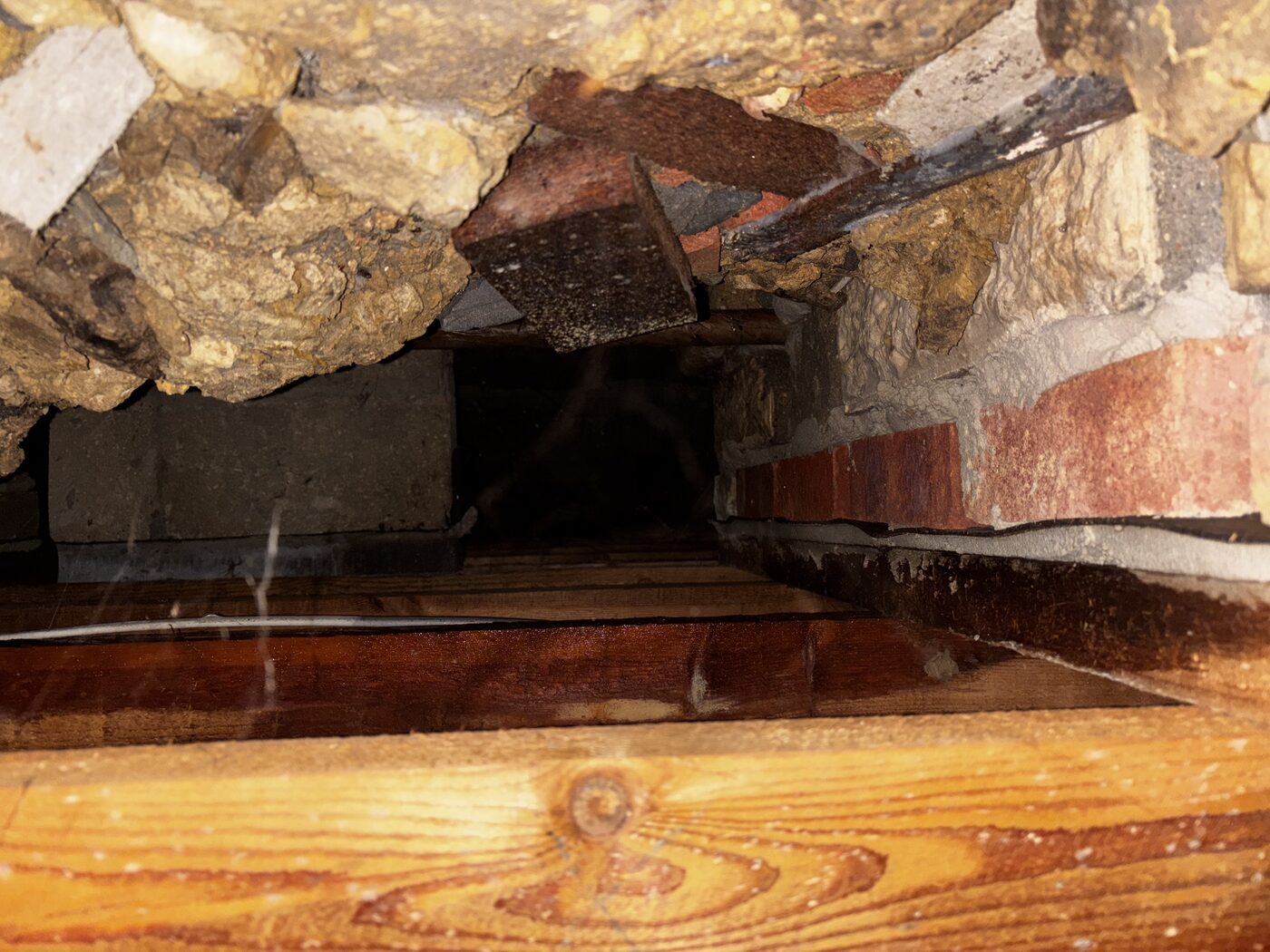 Looking into the subfloor void — old rubble foundations, very limited space