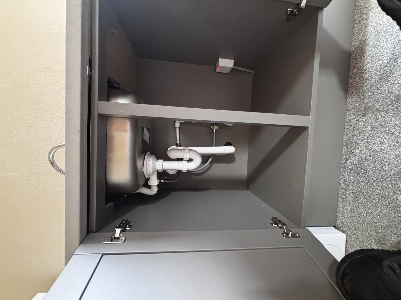 Under-sink plumbing complete — trap, waste, and supply valves all fitted and secure