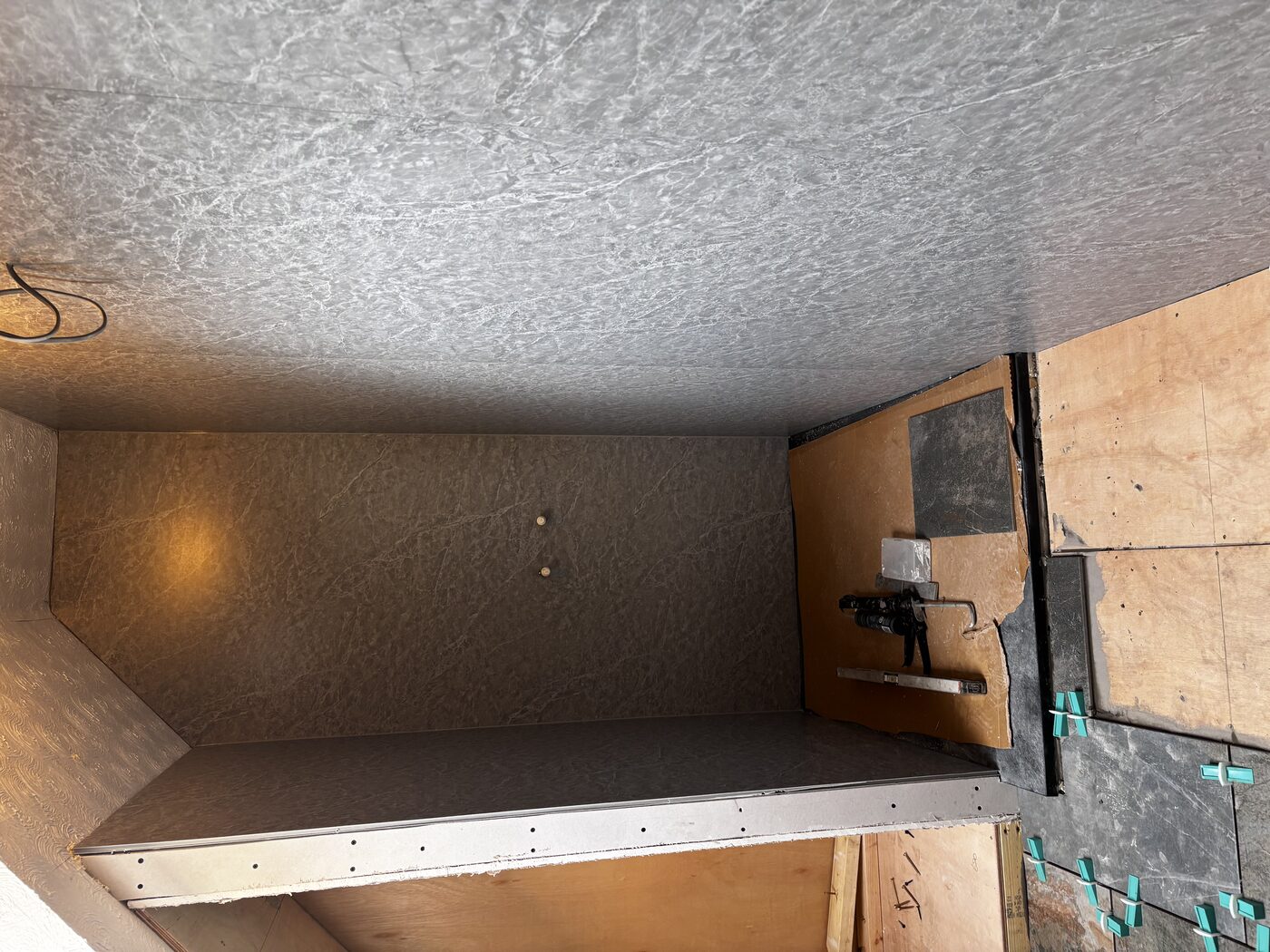 Inside the shower enclosure — panels fitted to all walls and sloped ceiling section