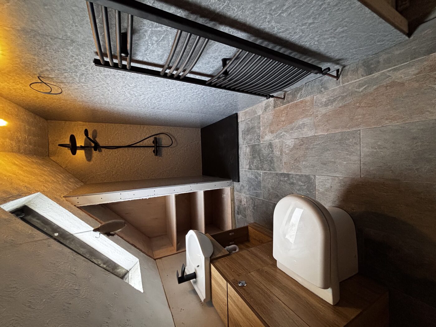 Finished — walk-in shower, oak vanity, wall-hung toilet, heated towel rail and stone-effect tiles
