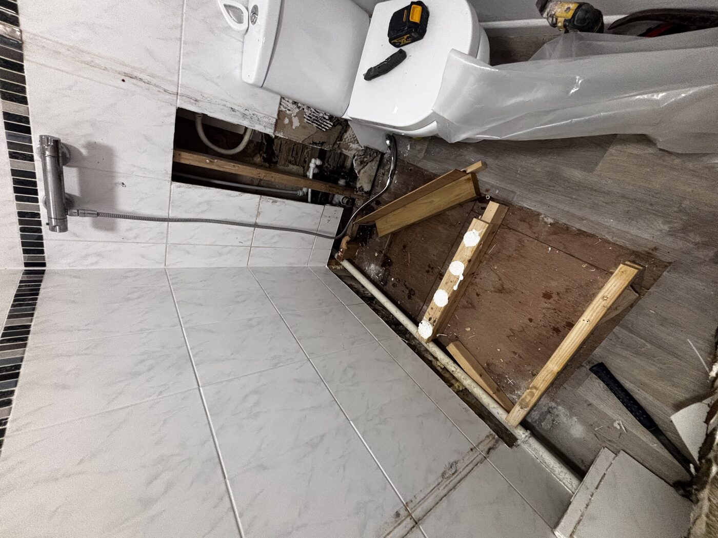 Shower stripped — water damage to subfloor exposed