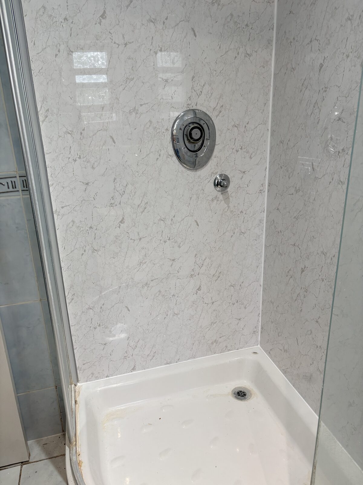 Marble-effect shower wall panels around the shower controls during installation