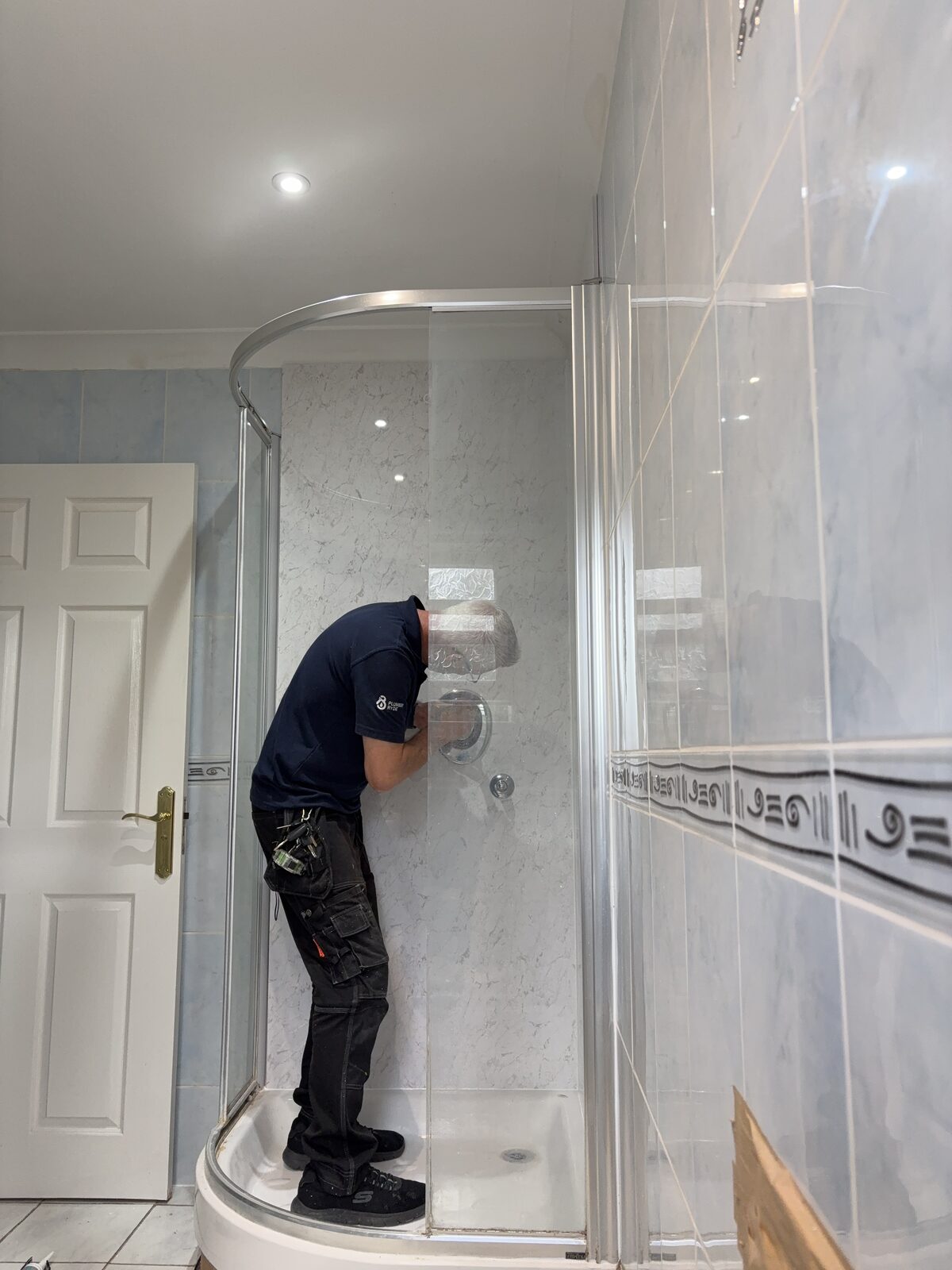 Steve working inside the shower enclosure during a shower-panel fitting job in Ryde